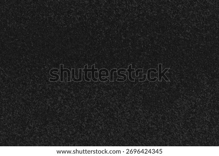 Textured black surface. Dark, slightly grainy appearance with subtle variations in tone. Uniform distribution of minuscule speckles