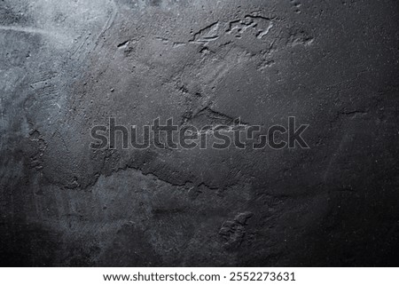 Textured black surface with subtle patterns in natural light