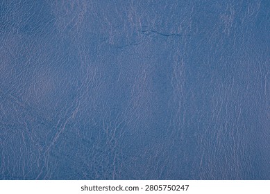 A textured blue leather surface with a subtle grain.