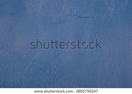 A textured blue leather surface with a subtle grain.