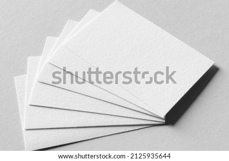 Textured business card mockup on a grey background.  85x55 mm.