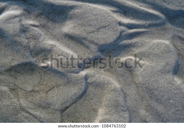 Textured close-up
background with wet brown sea sand, combined with flowing water,
placed in a beautiful
pattern