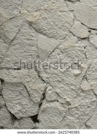 Textured close-up of light gray limestone rock surface. Natural, rough texture with visible cracks and variations. Ideal for backgrounds, geological studies, or construction material visuals