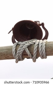 Textured Coarse Rope Wrapped Around Wooden Pillar With A Metal Vintage Dinner Bell 
On Top. Found At A Cabin Up North In Minnesota On A Lake With A Boat. 