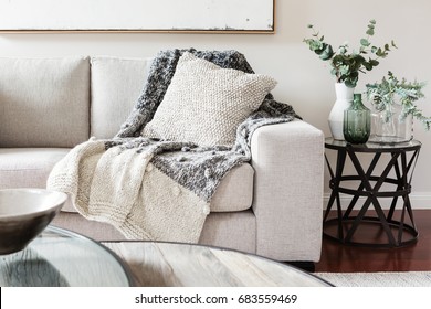 Textured layers interior styling of cushion sofa and throw in neutral colors