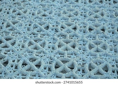 Textured pattern of a ski slope mat. Wide view of the modular plastic surface, dense short spikes and scattered shavings, for outdoor training on downhill skiing or snowboarding.
