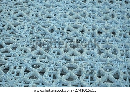 Textured pattern of a ski slope mat. Wide view of the modular plastic surface, dense short spikes and scattered shavings, for outdoor training on downhill skiing or snowboarding.