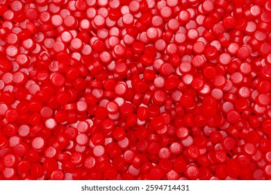 Textured patterned surface of vibrant shiny red gummy candy drops