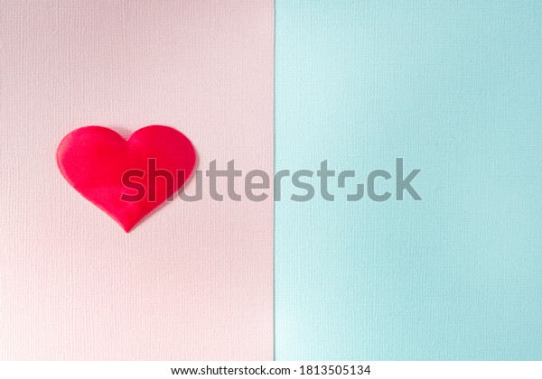 The textured pink\
and blue background is divided into equal parts. The pink part has\
a red heart. Copy space