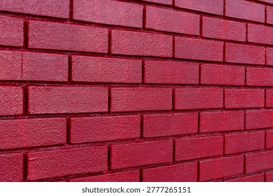 Textured red brickwork background surface. Close up texture of red painted brick wall