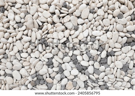 Textured rock pile on gravel ground, full of pebbles. Gravel background