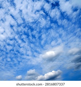 textured small cirrocumulus clouds turning into larger and denser cloud masses at the bottom of the photo