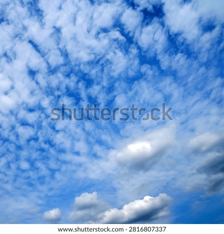 textured small cirrocumulus clouds turning into larger and denser cloud masses at the bottom of the photo