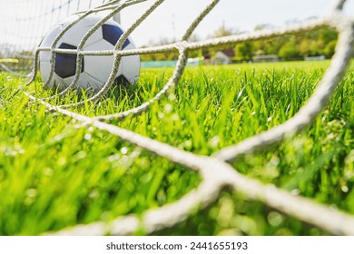 textured soccer game field with close-up ball in front of the soccer goal - soccer ball in soccer net. - Powered by Shutterstock