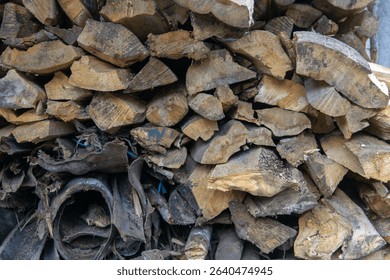 A textured stack of firewood sits ready, cut and piled, preparing for the cold months ahead.