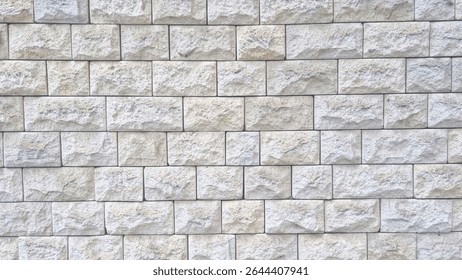 Textured stone wall with rectangular light grey beige blocks arranged in horizontal rows. Natural rough surface pattern for architecture and construction concept. Mockup stage template