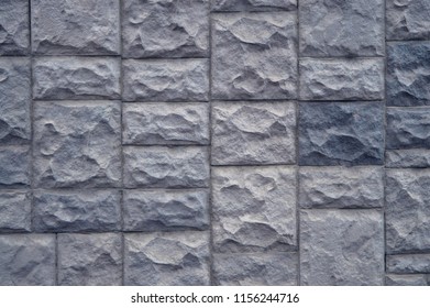 Textured stone walls built of large rough stones held together by  lumps of  cement . stones background. Rough natural stones. Background of a stone wall cladding texture brown stone bricks.