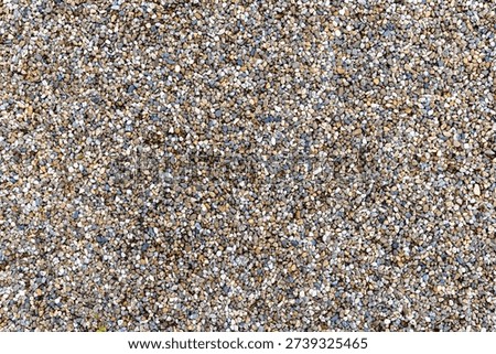 A textured surface composed of small, rounded stones, commonly identified as pea gravel