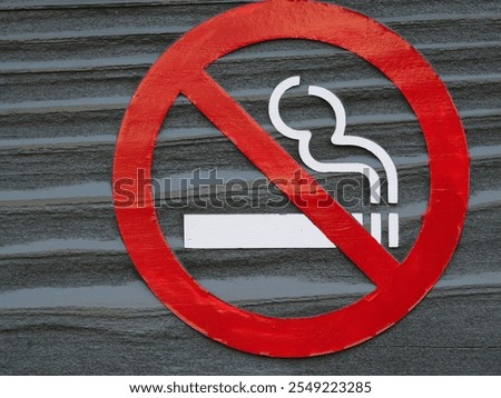 The textured surface of the wall adds depth to the image of the no smoking sign.
The sign is mounted on a rough, weathered surface.