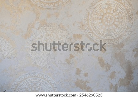 Textured wall with intricate mandala patterns and rustic beige tones, perfect for backgrounds, decor, and bohemian design projects.