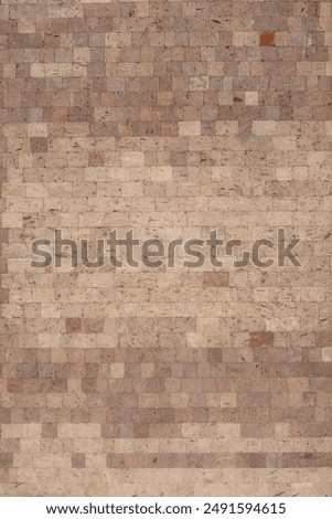 The textured wall is lined with volcanic tuff tiles of various shades.