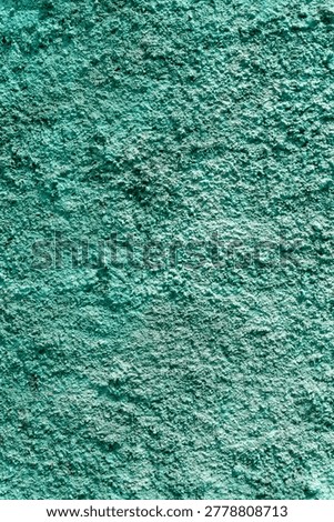 textured wall surface features a rough, grainy texture that resembles plaster or concrete. It can be a bright aquamarine, turquoise, or bluish-green. Vertical image