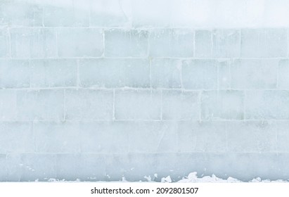 Textured white translucent surface of an ice wall, made of large bricks.