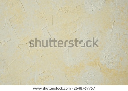 Textured yellow wall with plaster pattern and warm decorative effect