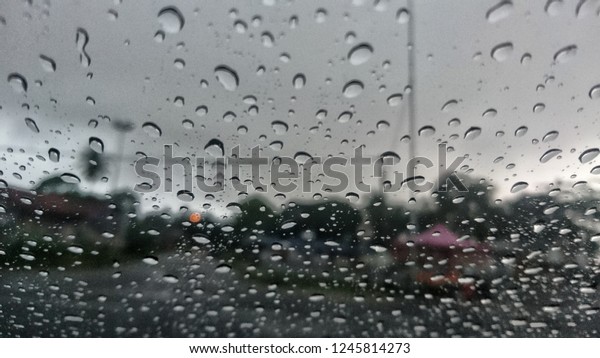 Textures of\
water droplets of rain flow down the windowpane. Rain drop on the\
car glass background. Selective focus.\
