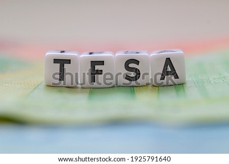 TFSA letters on white blocks with bills on a clear background