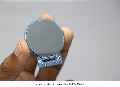 TFT LCD of round shape held in the hand. Digital LCD screen display for electronics