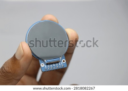 TFT LCD of round shape held in the hand. Digital LCD screen display for electronics