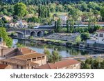 A TGV high speed train passes over a bridge on the River Orb at Beziers, Herault, south of France, contrasting with the old houses of the city