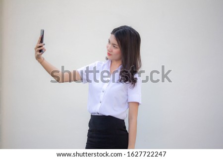 thai adult student university uniform beautiful girl using her smart phone Selfie