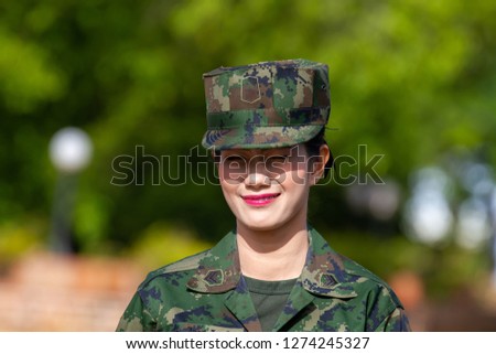 Thai army soldier woman in green camouflage uniform.