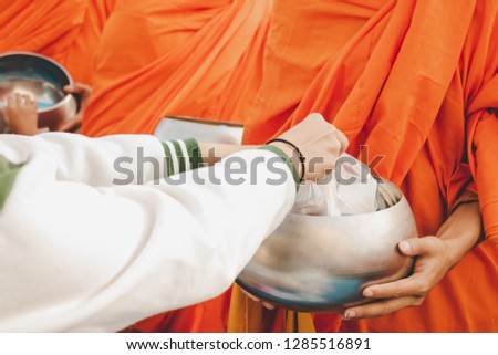 Thai Buddhist to do good things make merit by offer food to the monk. Concept inherit thai culture.