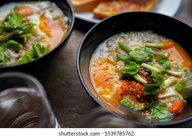 Thai Congee With Minced Pork And Egg Is A Favorite Breakfast For Thai People. On Wood Table Texture.