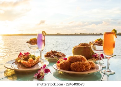 Thai cuisine set, grilled river prawn, catfish curry, curry steamed seafood in a coconut cup, and deep-fried shrimp cake served with wine and raw oysters. - Shutterstock ID 2248408593