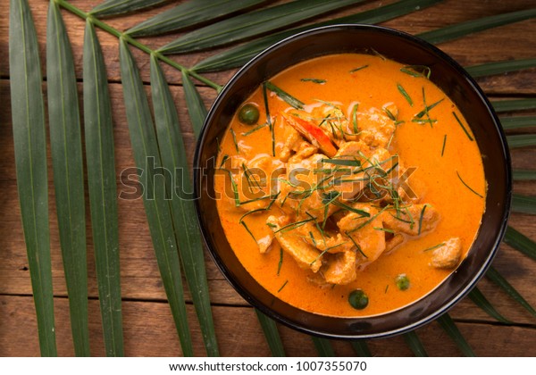 Thai curry red\
soup,Thailand tradition red curry with beef,pork or chicken menu in\
thai name is panaeng.Curry menu with coconut milk.Panaeng Curry on\
Wooden table