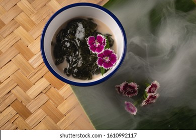 Thai dessert, Icevine, Pareira barva with coconut milk on wooden table, Top view - Shutterstock ID 1610992117