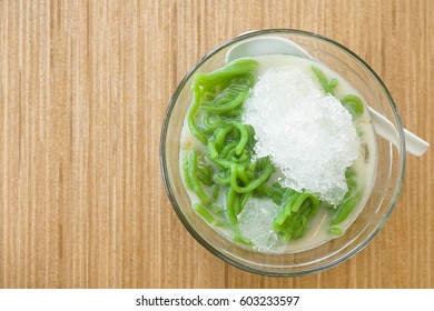 Thai dessert, rice noodles made of rice and coconut milk with shaved ice on wooden table, Top view. Cendol or Lod-chong, in Thai, is a popular dessert in Southeast Asian countries.
 