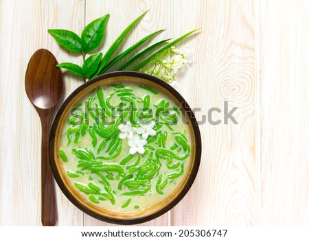 Thai dessert, rice noodles made of rice eaten with coconut milk on wooden table, Top view 