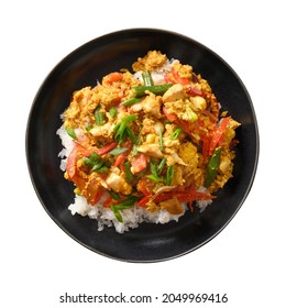 Thai dish Gai Pad Pongali with chicken, eggs, spicy, yellow thai curry paste, tomatoes on rice in black bowl isolated on white background. Pan-Asian cuisine. Thai Stir Fried food and meal.