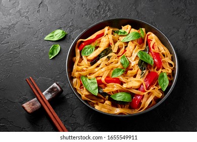 Thai Drunken Noodles Or Pad Kee Mao In Black Bowl At Dark Slate Background. Drunken Noodles Is Thai Cuisine Dish With Rice Noodles, Chicken Meat, Basil, Sauces And Vegetables. Thai Food. Copy Space