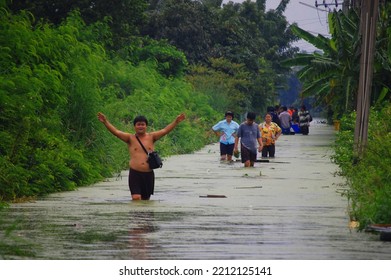 Thai Family People Natural Disaster Victims Walking Wading In Water On Street Of Alley While Water Flood Road Go Receive Goods Donations At Countryside Rural On October 20, 2011 In Nonthaburi Thailand