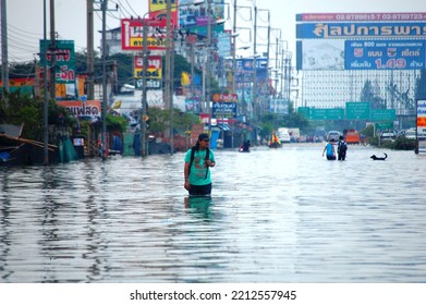 Thai Family People Natural Disaster Victims Walking Wading In Water On Street Of Alley While Water Flood Road Go Receive Goods Donations At Countryside Rural On October 20, 2011 In Nonthaburi Thailand