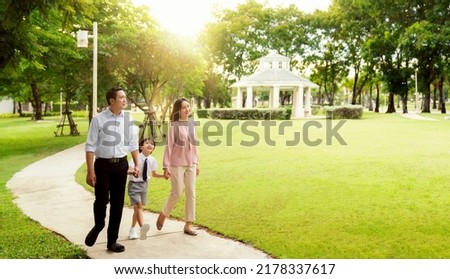 Thai family walking togather to go to working and go to school at morning in the pavilion park