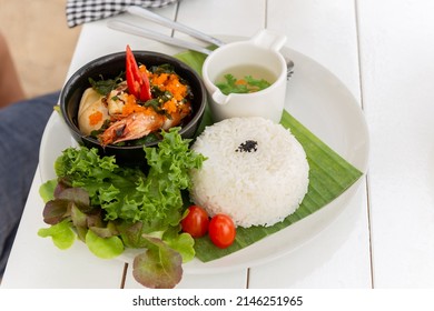 Thai famous dish pad kra pao stream rice with king prawn and vegetable soup.