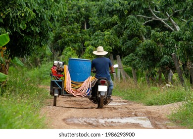 Thai farmers riding motorcycle trailer Carrying agricultural tools to work in the garden