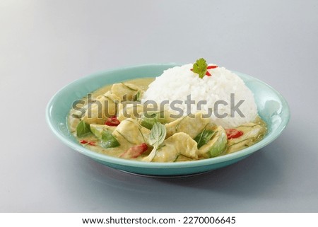 Thai food, Thai chicken green curry with stream rice (Kang Kiew Wan) in a green plate on grey background.